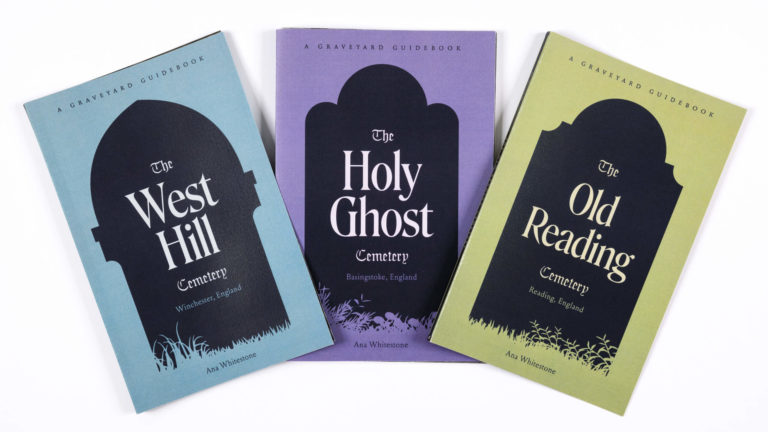 Three books on a white background fanned out. Each book has a black tombstone shape on the cover. From left to right they are blue, purple, and green.