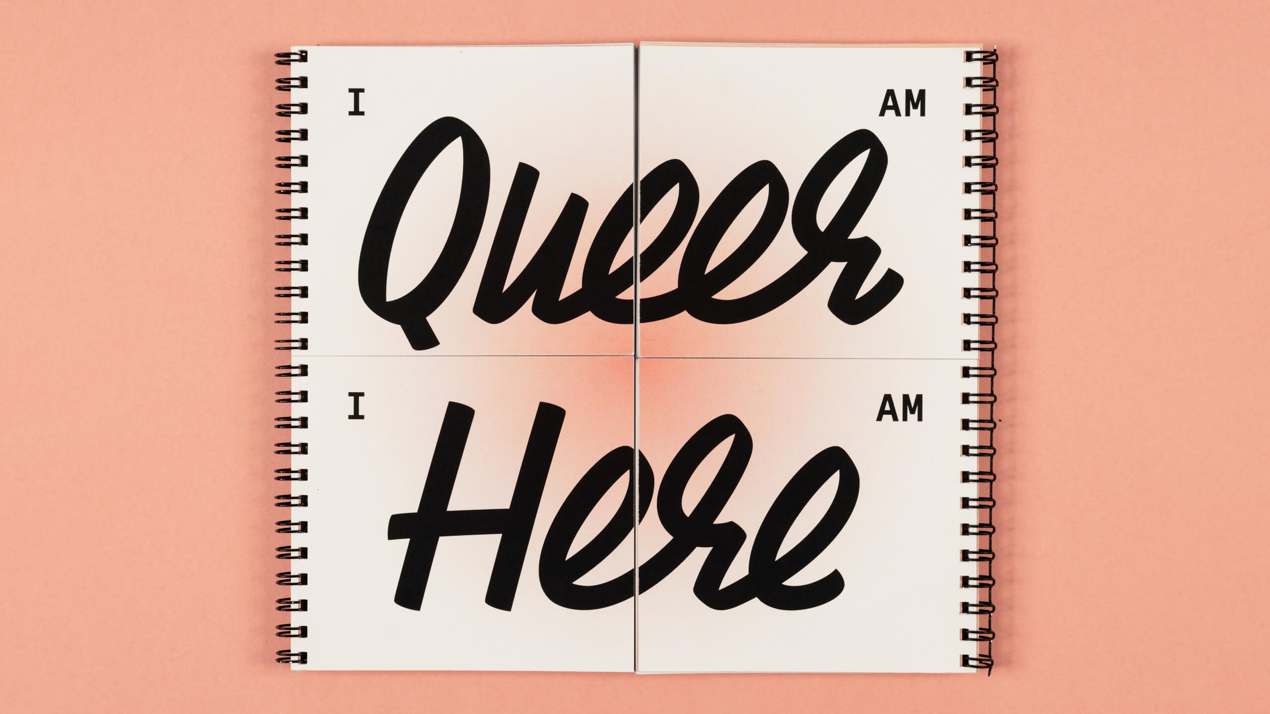 A white square book on a pink background. The cover of the book reads 'I am Here I am Queer'. The book has a pink circular gradient in the middle, and black wire binding on the left and right sides.